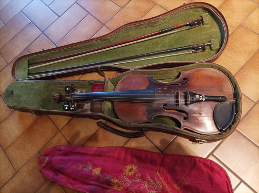Antico violino della prestigiosa famiglia Guadagnini accompagnato da due archetti e da colofonia d’origine nonostante una leggera crepa sulla faccia anteriore