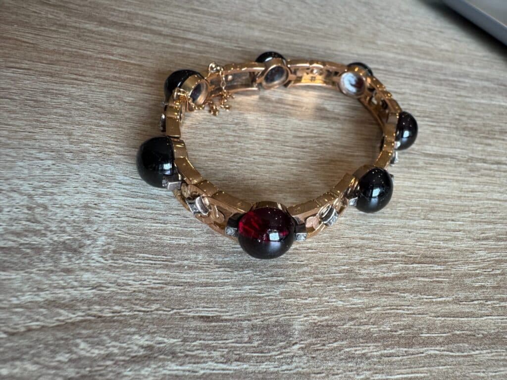 Magnifico bracciale d’epoca in oro decorato con pietre rosso scuro e nere